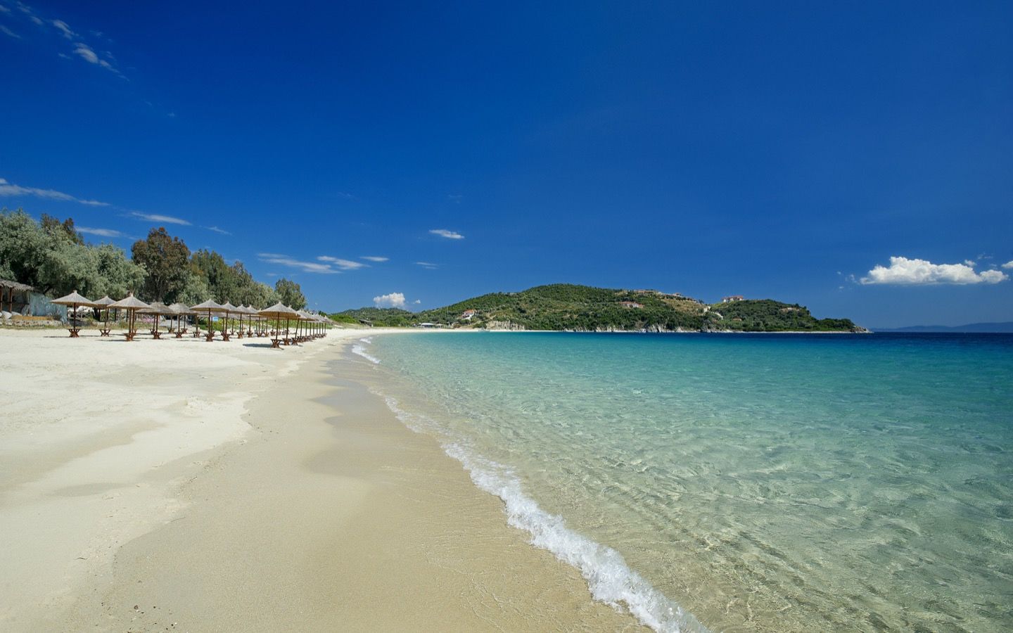 Sandy beach with thatched umbrellas on Ammouliani Island, Halkidiki